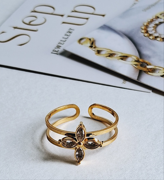 Gold ring with a leaf design on a magazine with jewelry section text